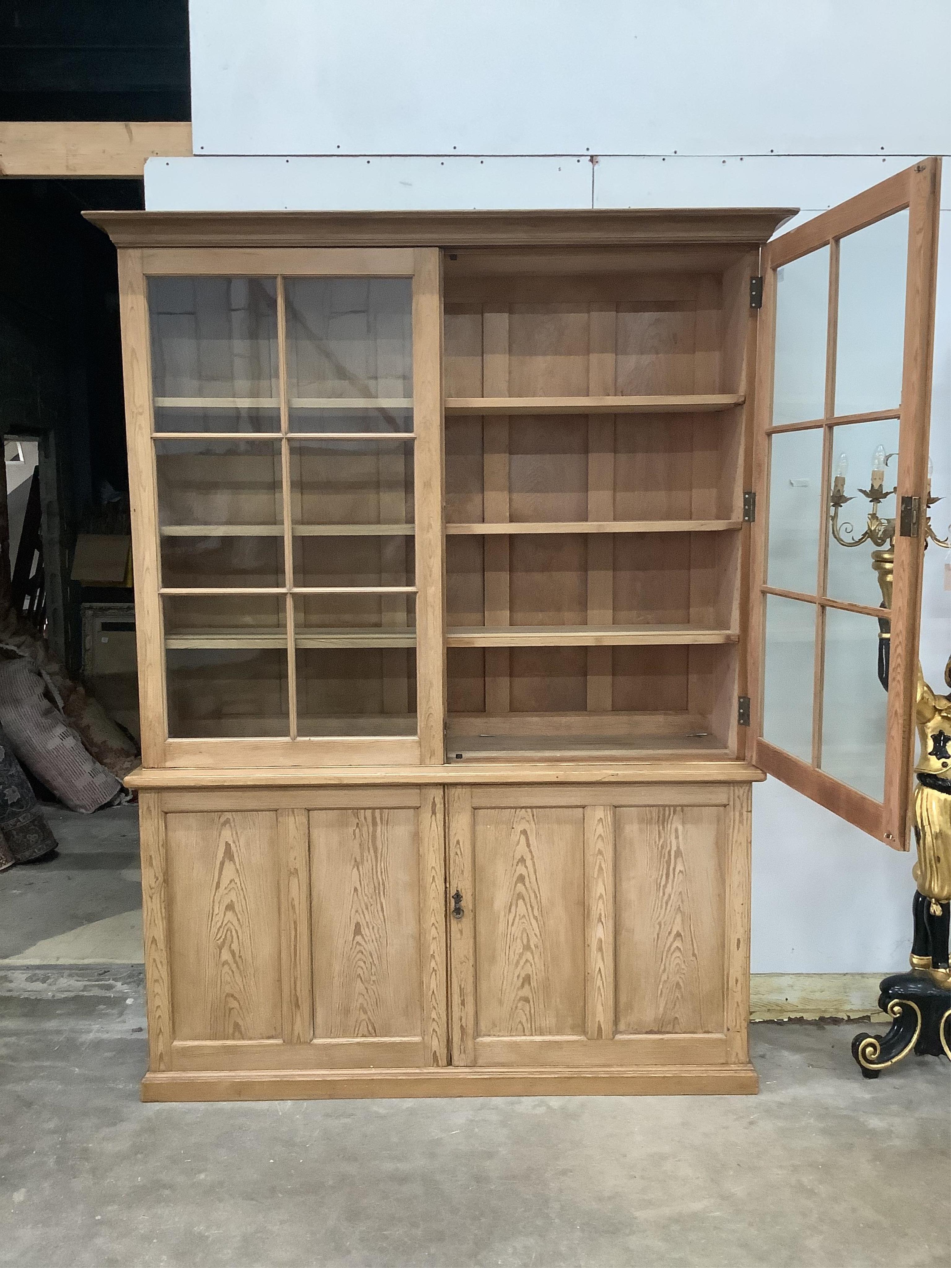 A Victorian pitch pine bookcase / cupboard with compartmented panelled base, width 168cm, depth 42cm, height 231cm. Condition - good